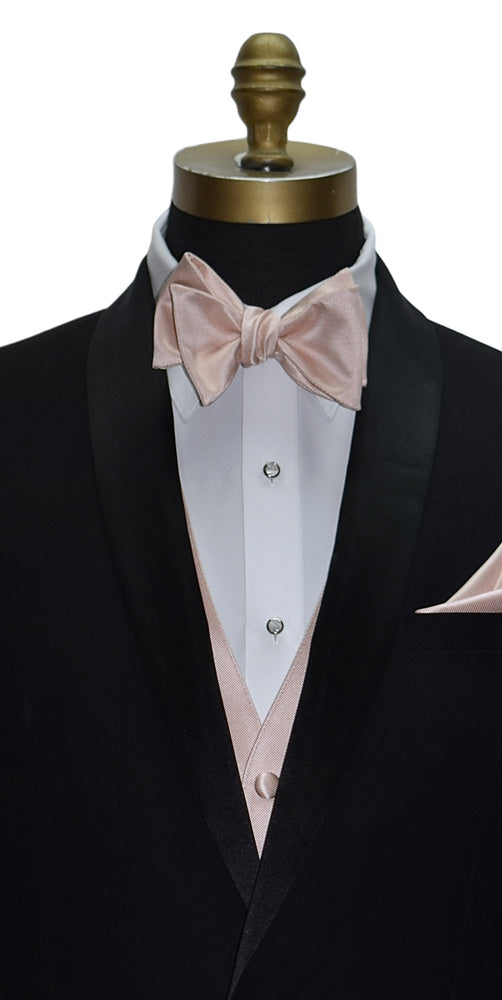 very close front view mannequin wearing a black shawl collar tuxedo with a petal color "tie-yourself" bowtie and petal vest against a white background