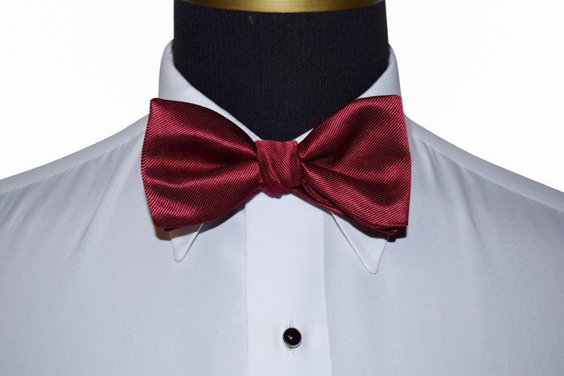 apple colored bow tie on a white shirt with black lapels