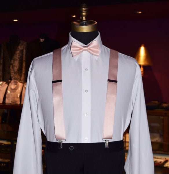 mannequin wearing a white tuxedo shirt with a blush pre-tied bow tie inside of a tuxedo shop