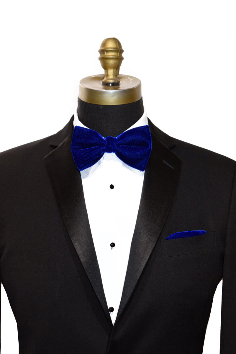 Black tuxedo with a royal blue velvet bow tie and pocket square on a mannequin against a white background
