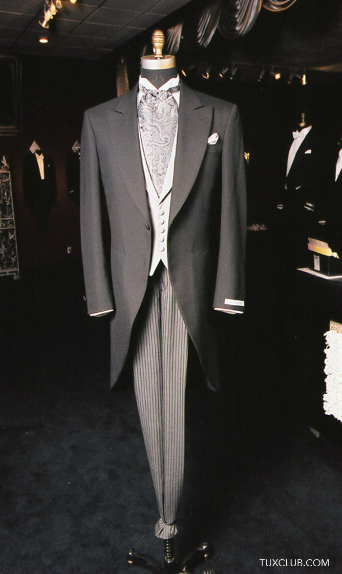 Full length mannequin wearing a charcoal cutaway morning suit with paisley ascot and gray striped pants in a tuxedo shop