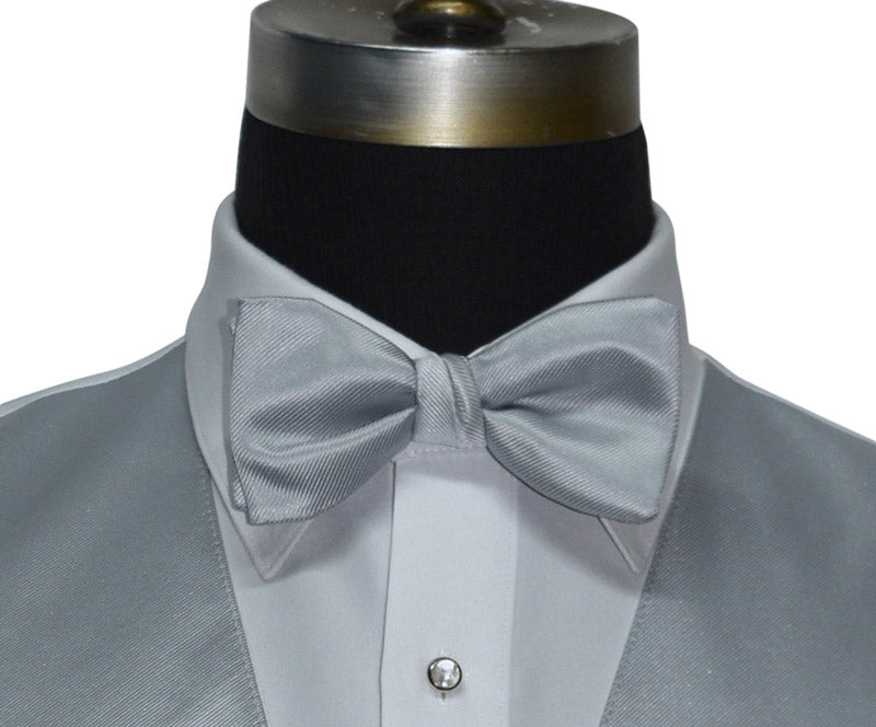 super close-up silver pre-tied bowtie and silver vest on a mannequin against a whitw background