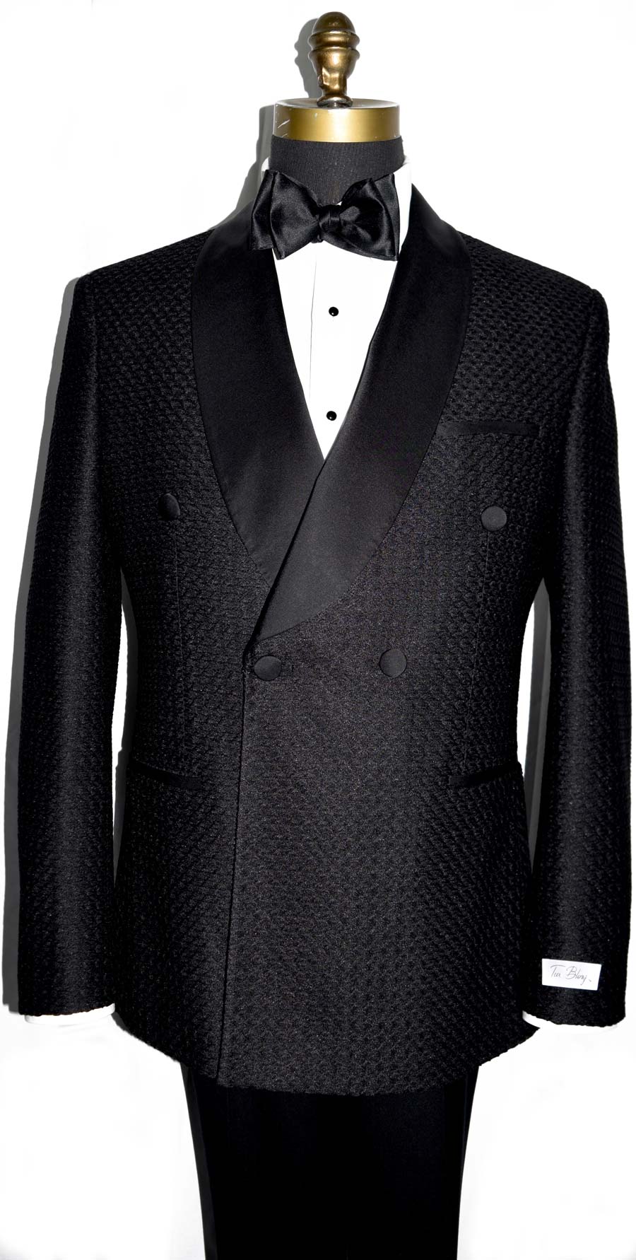 close-up front view black double-breasted shawl collar tuxedo with a black bow tie against a white background 