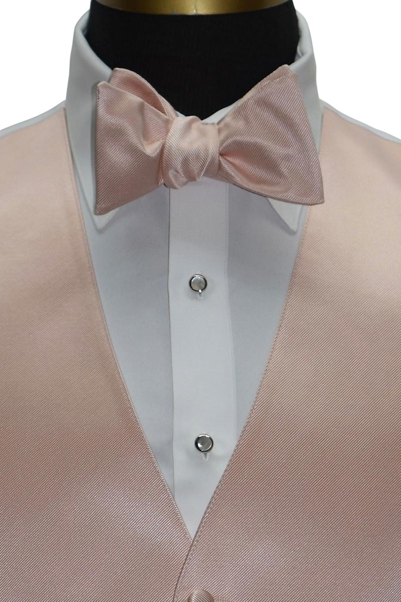close up view of a mannequin wearing a blush "tie-yourself" bowtie mand vest against a white background