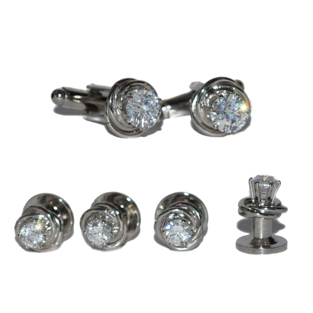 close-up cubic zirconia cufflinks and studs set in silver setting against a white background 