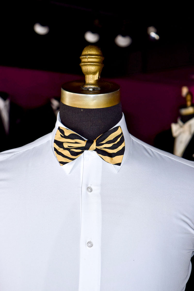 Mannequin wearing a white shirt with a brown and black zebra print bow tie against a dark background