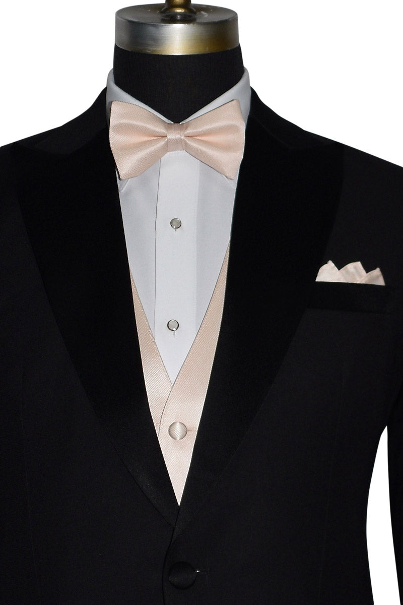 very close black tuxedo wearing a nude "pre-tied" bowtie and nude vest against a white background