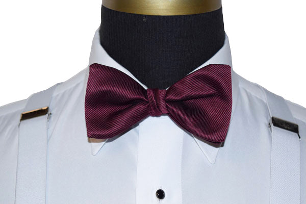 wine bow tie on a white dress shirt with white suspenders