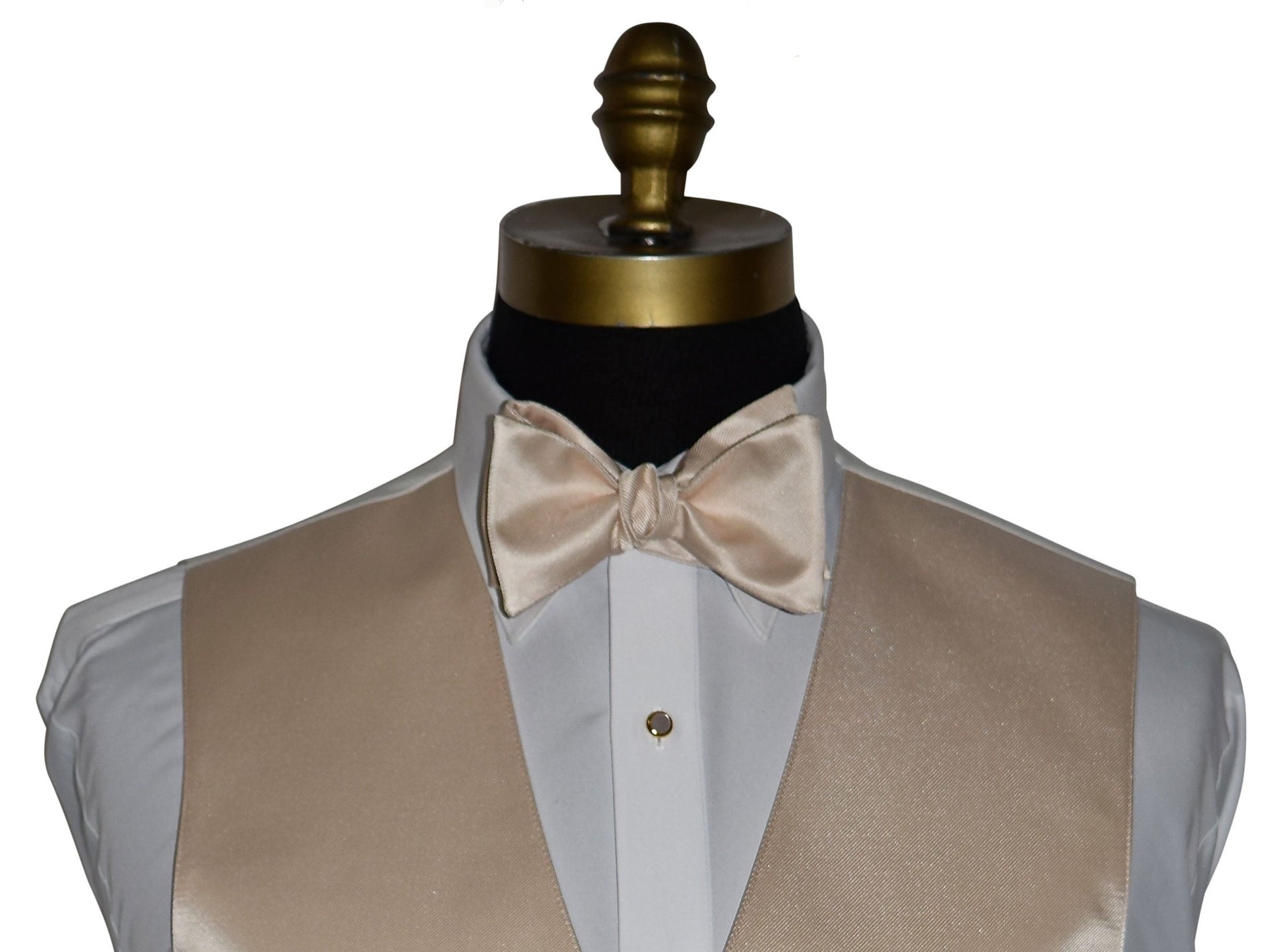 very close up champagne "tie-yourself" bowtie and champagne vest on a mannequin against a white background