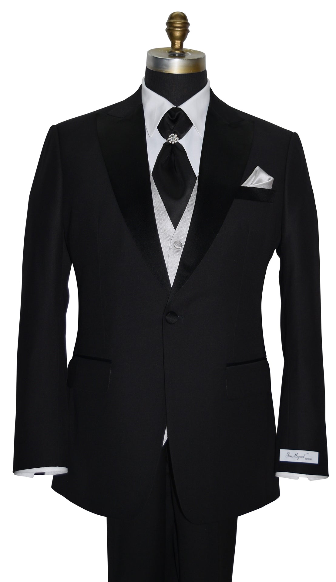 Black peak lapel tuxedo with white shirt and black cravat and gray vest on a mannequin against a white background