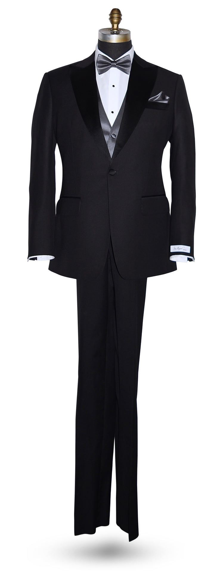 Black peak lapel tuxedo  tuxedo on a mannequin wearing a charcoal bowtie and charcoal vest against a white background