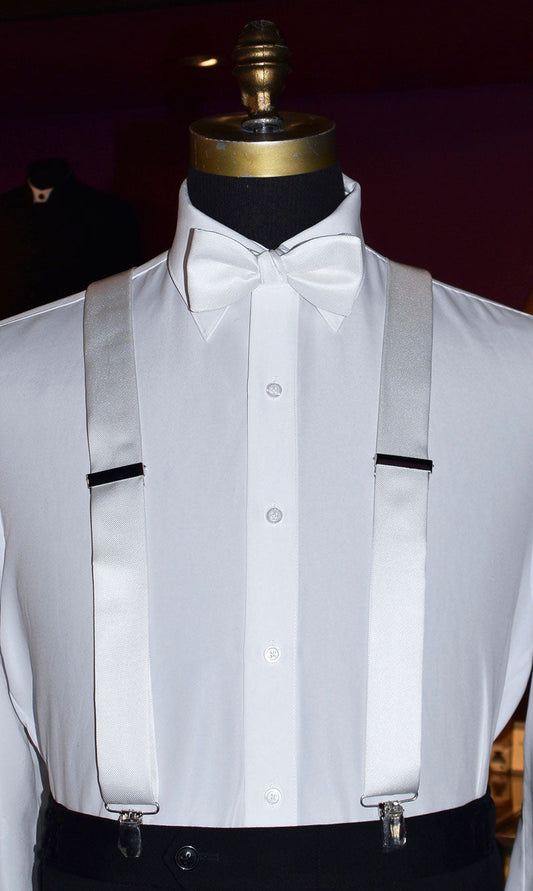 white satin suspenders and bowtie on a mannequin at a tuxedo shop