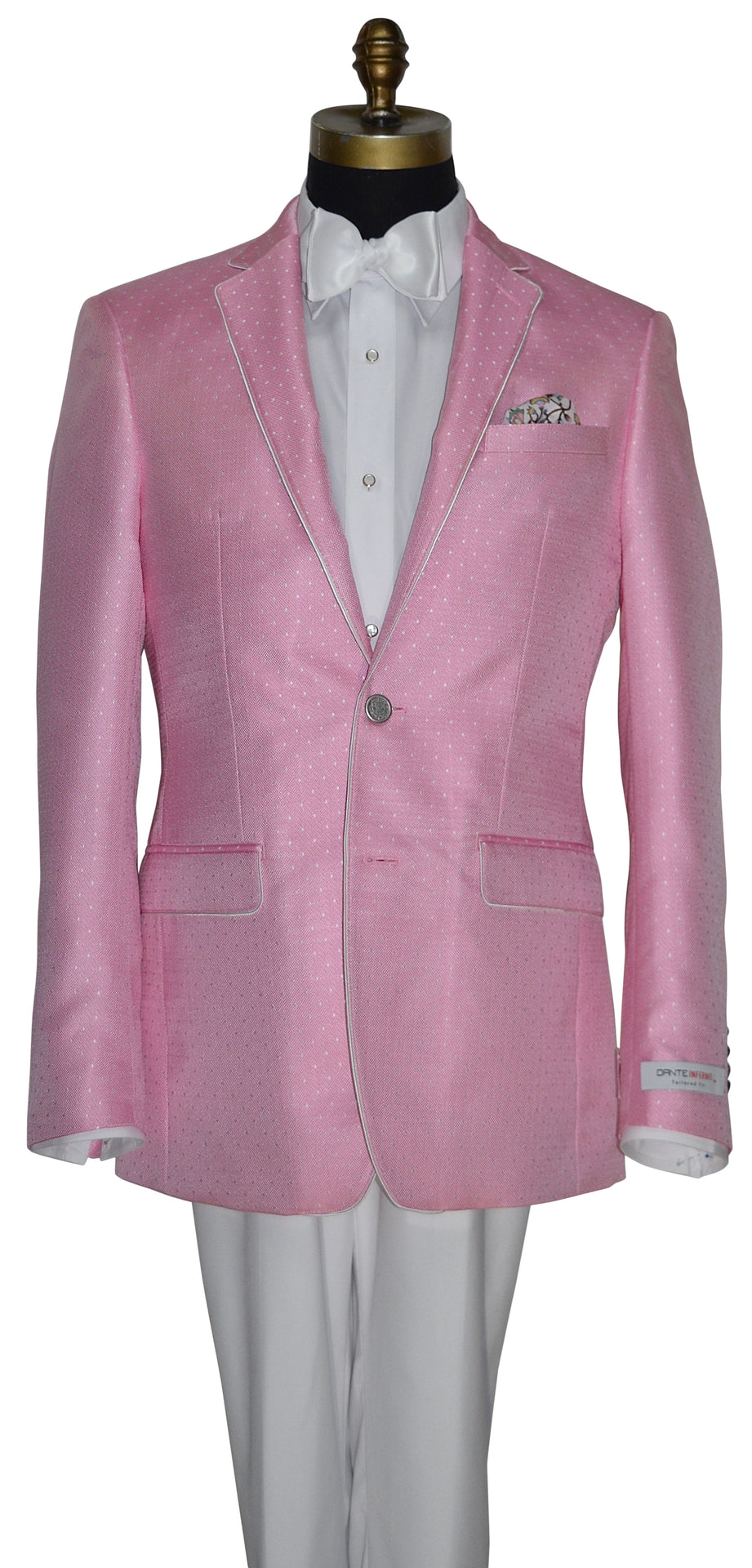 close up of Bermuda pink jacket wearing a white tuxedo shirt and white bowtie against a white background.
