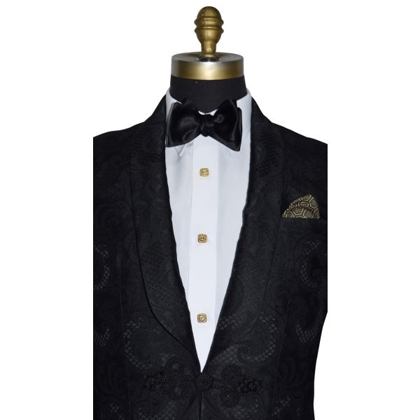 very close up mannequin wearing Black shawl collar dinner jacket with brocade pattern shown with white tuxedo shirt and black bow tie on a white background