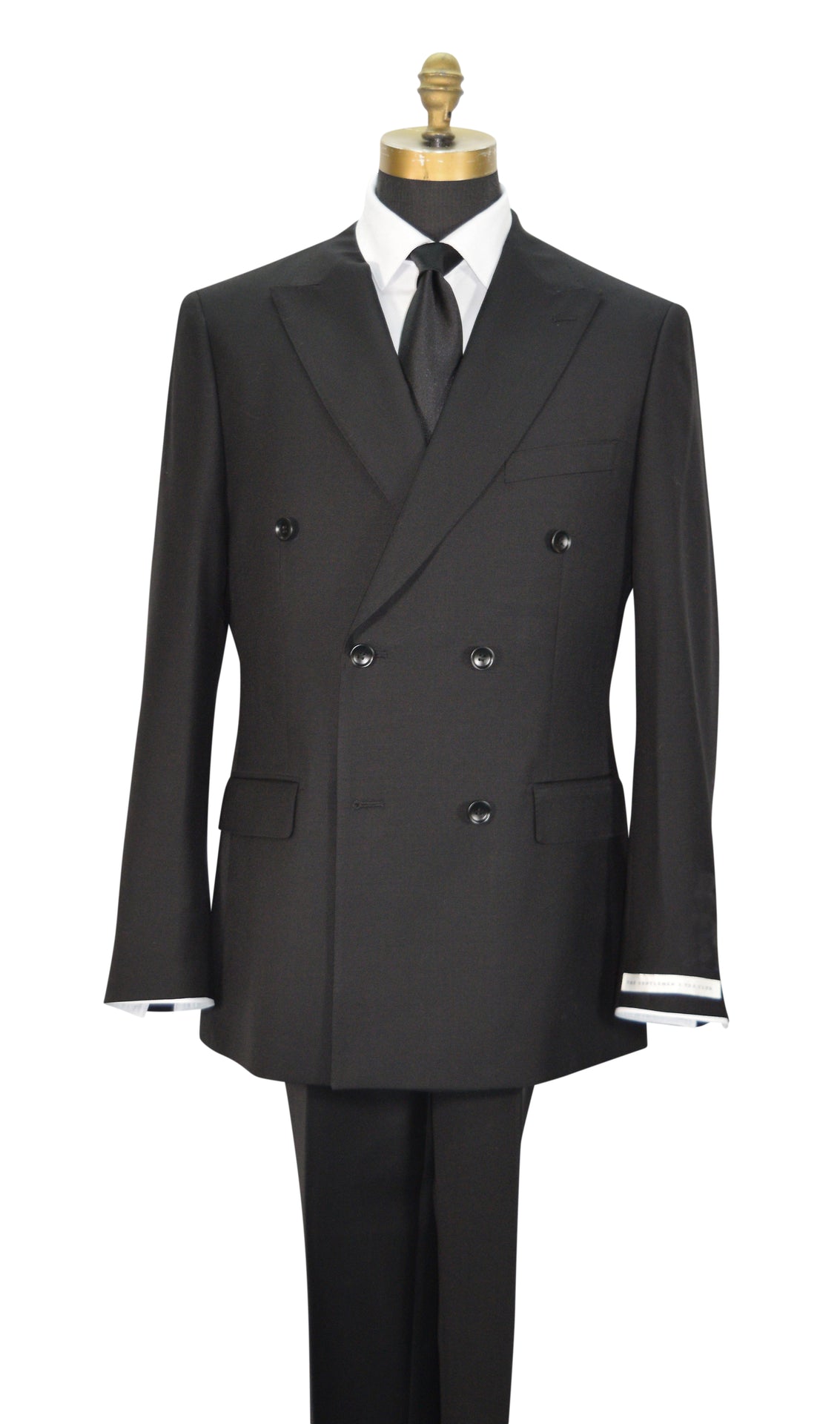 A black double-breasted men's suit displayed on a mannequin torso with a white dress shirt, black necktie, and black trousers. The jacket features peak lapels, six buttons, flap pockets, and super lightweight tropical wool.