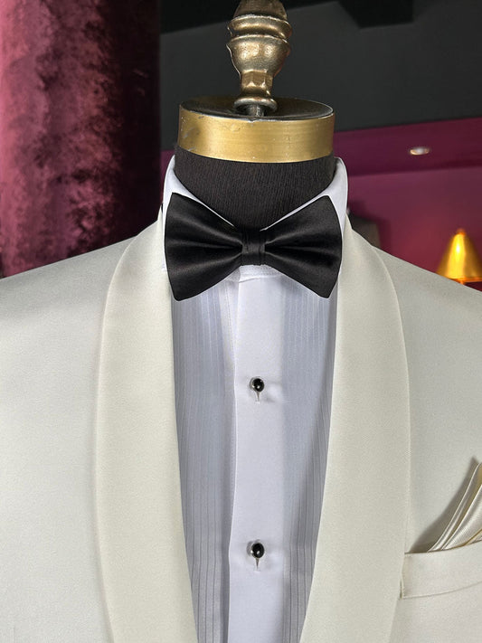 Off-white tuxedo with a black bow tie on a mannequin against a dark background.