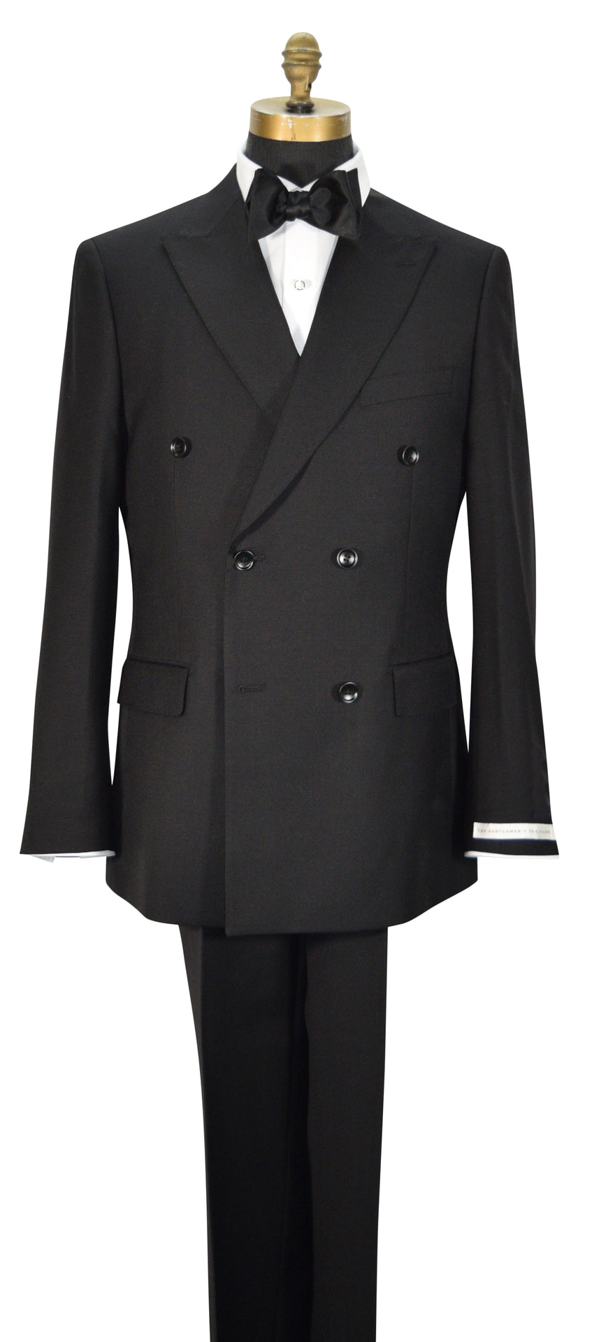 close-up mannequin wearing black double-breasted men's suit displayed on a mannequin torso with a white dress shirt, black bowtie, and black trousers. The jacket features peak lapels, six buttons, flap pockets, and super lightweight tropical wool.