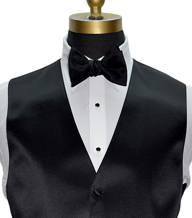 mannequin wearing a Black tuxedo vest and tuxedo shirt with a black bowtie and silver and black studs and cufflinks against a white background