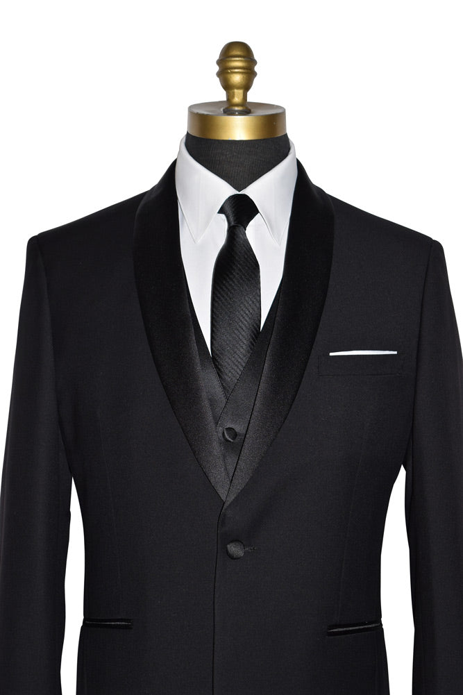 close-up black wedding tuxedo with a long black necktie and a black four-button tuxedo vest on a manneqin against a white background