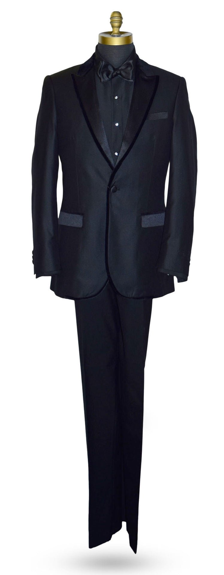 life size mannequin wearing a black peak lapel tuxedo with velvet trim on the lapel with a black tuxedo shirt and black satin tie-yourself bowtie against a white background