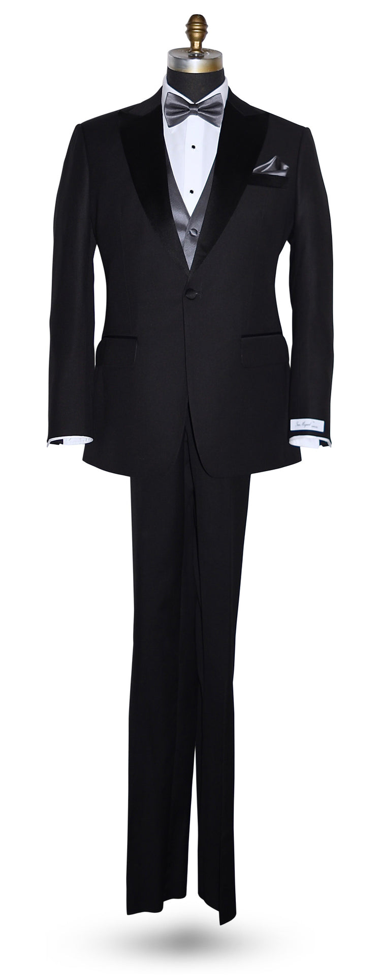 life size mannequin wearing a black notch-lapel tuxedo with a "San Miguel Especial" branded label with a charcoal tuxedo vest and charcoal pre-tied bowtie and pocket handkerchief against a white background