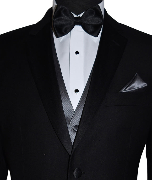 close-up front view Mannequin wearing a black notch-lapel tuxedo with a white dress shirt and a charcoal tuxedo vest with a black satin bowtie against a white background