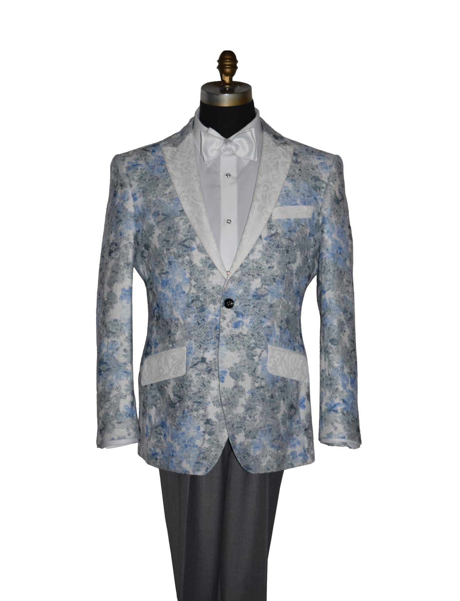 close-up blue and gray floral-patterned tuxedo jacket with a white bowtie and gray pants on a mannequin against a white background