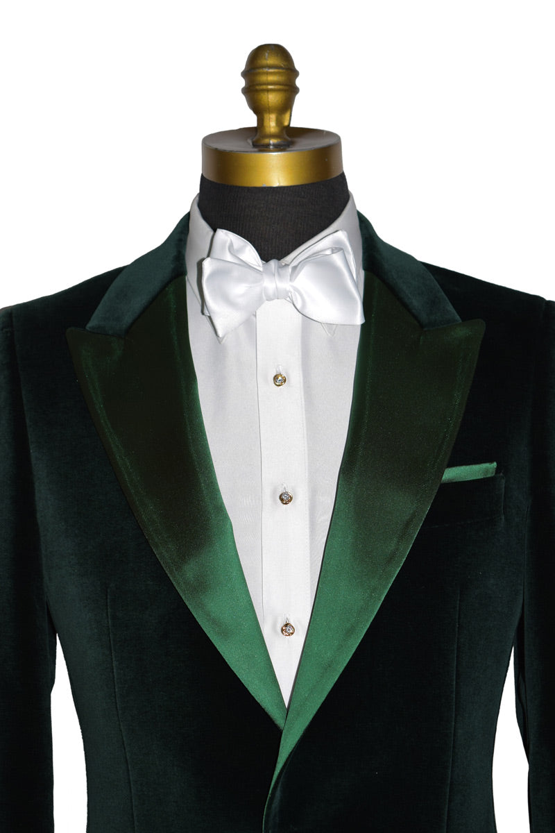 Green tuxedo jacket with white shirt and bow tie on a mannequin with cubic zirconia studs and cufflinks against a white background