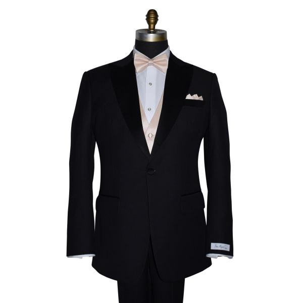 black tuxedo with nude pre-tied bowtie and nude color pocket handkerchief against a white background