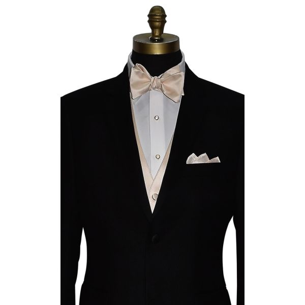 close-up mannequin wearing a black tuxedo with white tuxedo shirt and champagne "tie-yourself" bowtie and champagne vest against a white background