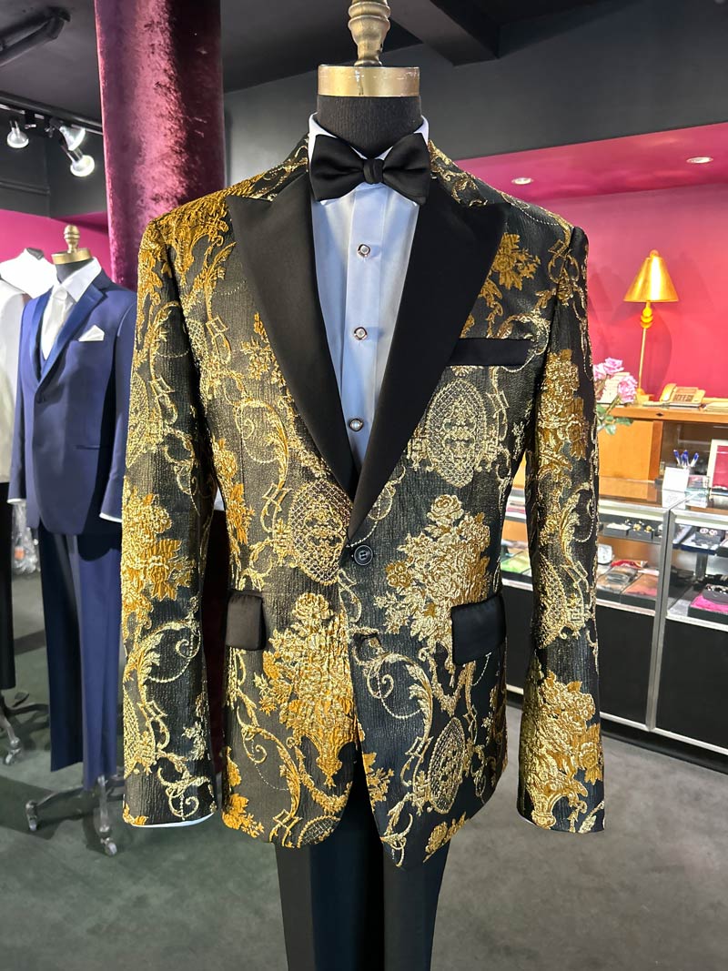 gold and black brocade tuxedo on a mannequin inside a fancy tuxdeo shop