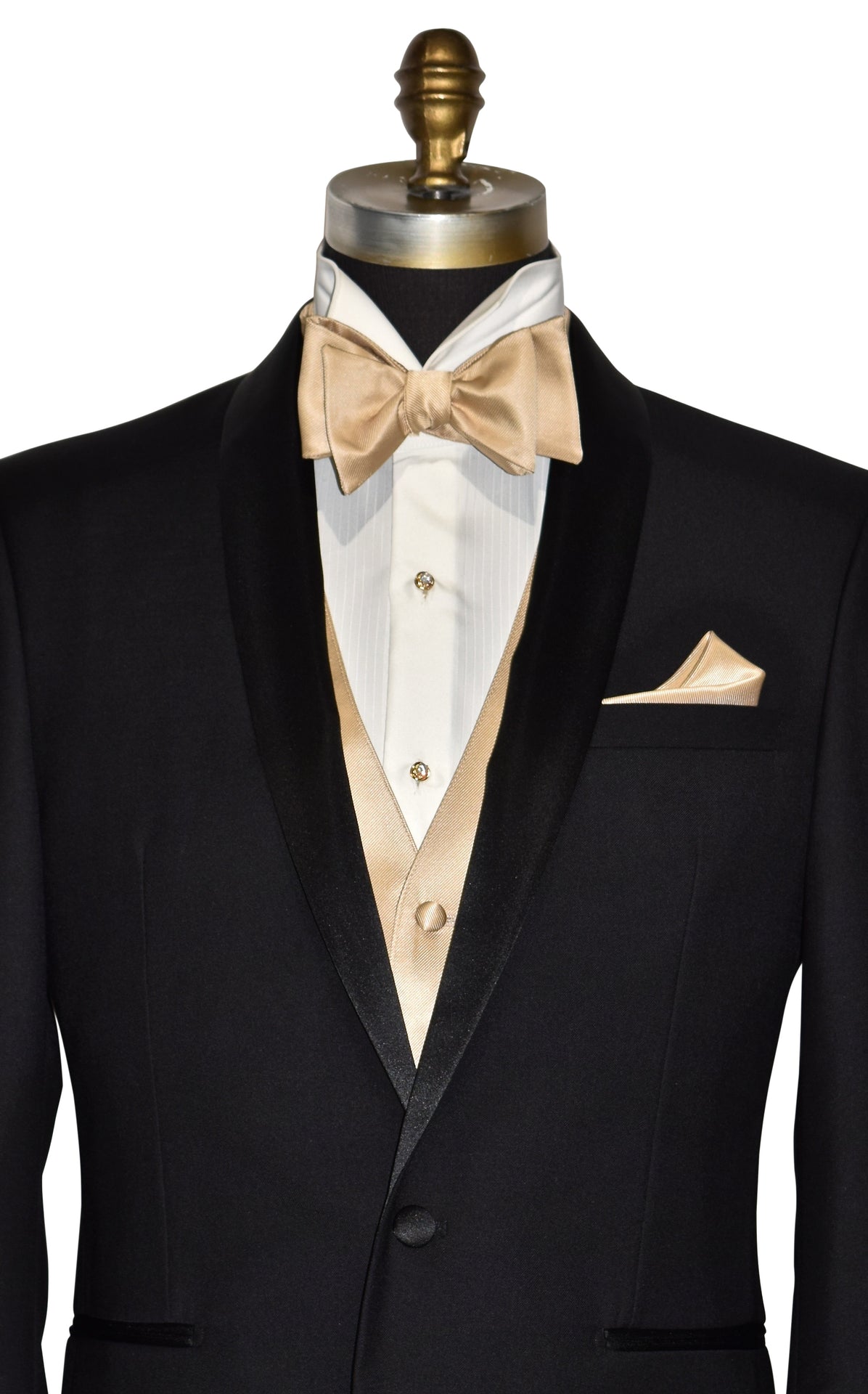 close-up Black shawl collar tuxedo with golden vest and bow tie and pocket square on a mannequin against a white background