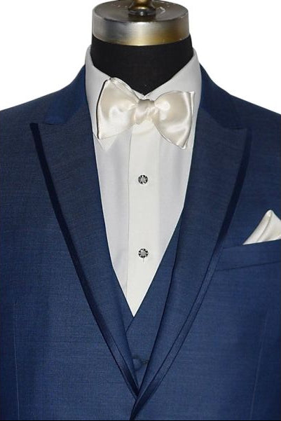 close-up front view-mannequin wearing a blue tuxedo with an ivory tuxedo shirt and an ivory "tie-yourself" bowtie against a white background