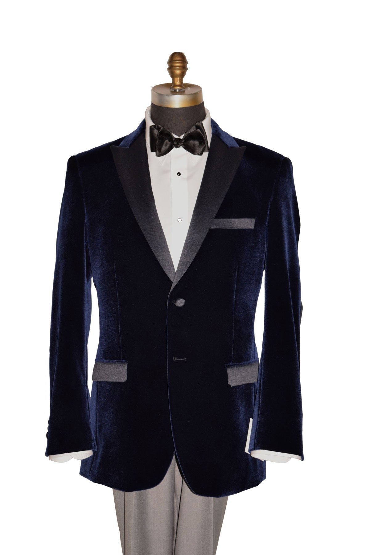 Navy velvet tuxedo with white shirt and black bow tie on a mannequin against a white background