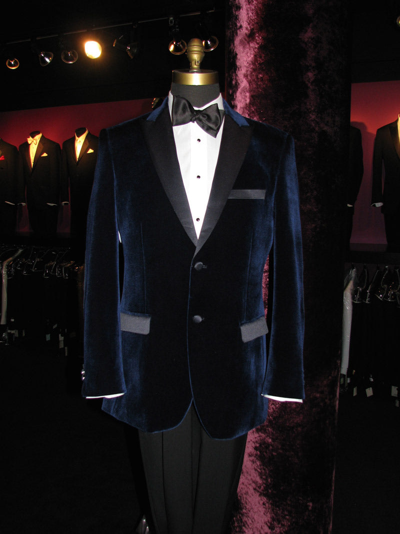 Blue velvet tuxedo on a mannequin on display inside a fancy tuxedo shop