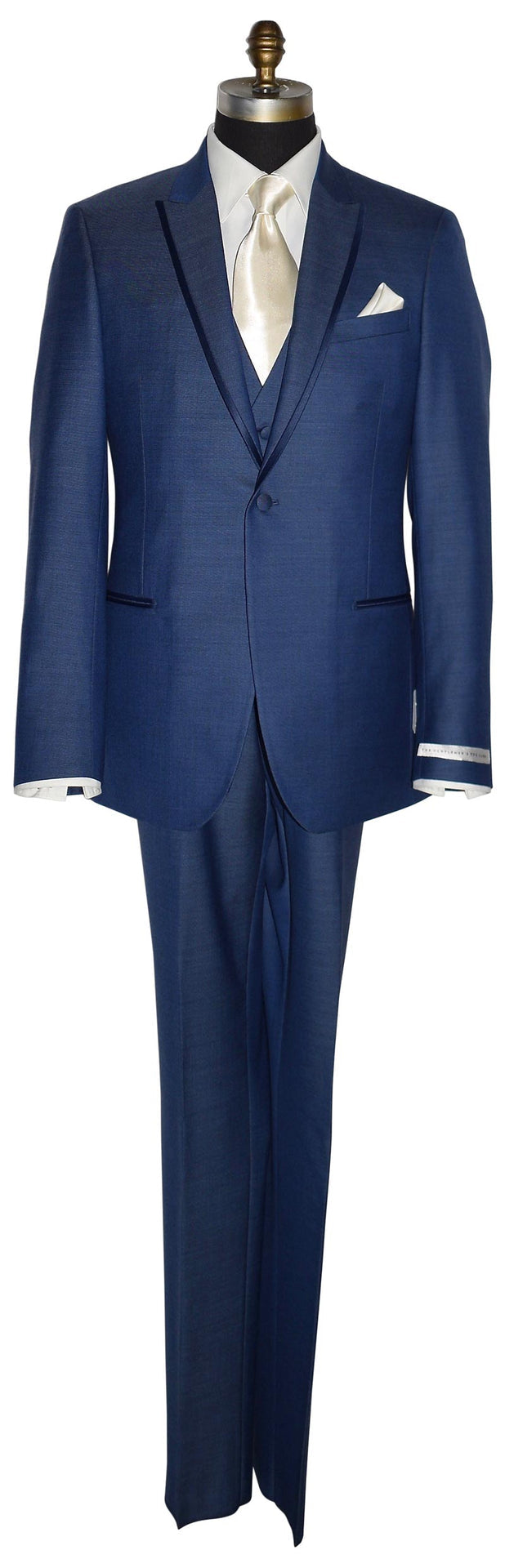 life-size mannequin wearing a new-blue three piece tuxedo with an ivory dress shirt with an ivory long necktie and ivory pocket handkerchief against a white background