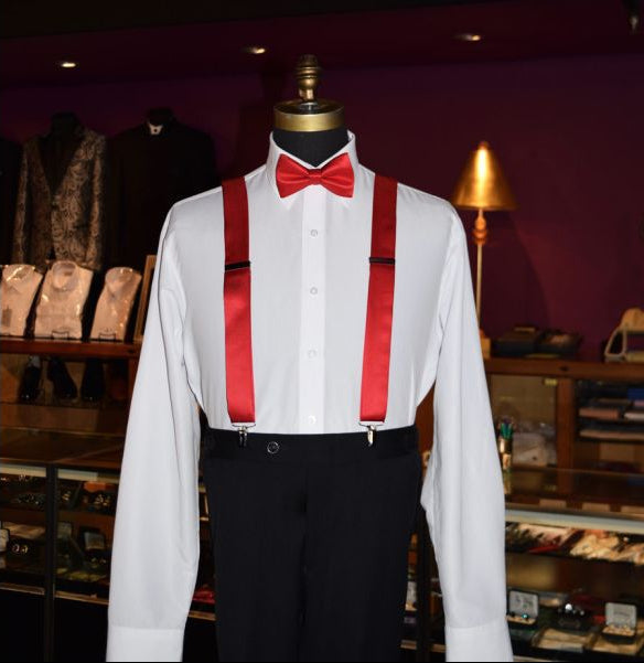 mannequin wearing red suspenders with a red pre-tied bow tie inside of a  tuxedo shop