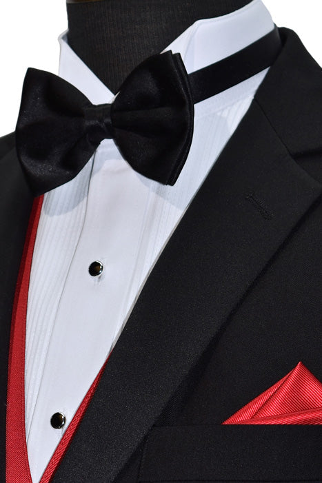 close-up black tuxedo with a white tuxedo shirt and black satin bowtie with a ruby-red tuxedo vest and pocket handkerchief against a white background