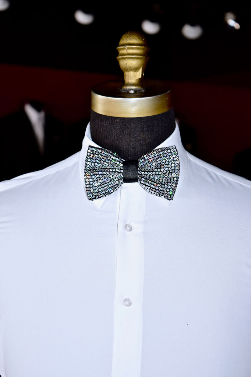 Mannequin wearing a white shirt with a silver sequin bow tie inside a tuxedo shop