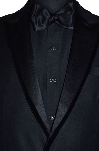 close up front view mannequin wearing "skull and bones" cufflinks and studs on a black tuxedo with a black tuxedo shirt and black bowtie