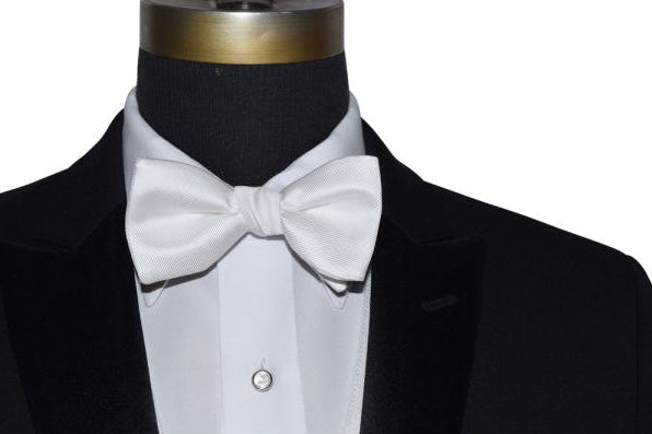 mannequin wearing a black tuxedo with a white shirt and a white bowtie