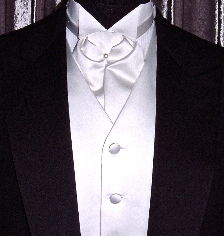 close-up mannequin wearing a black tuxedo with white satin vest and white satin ascot  in a store setting