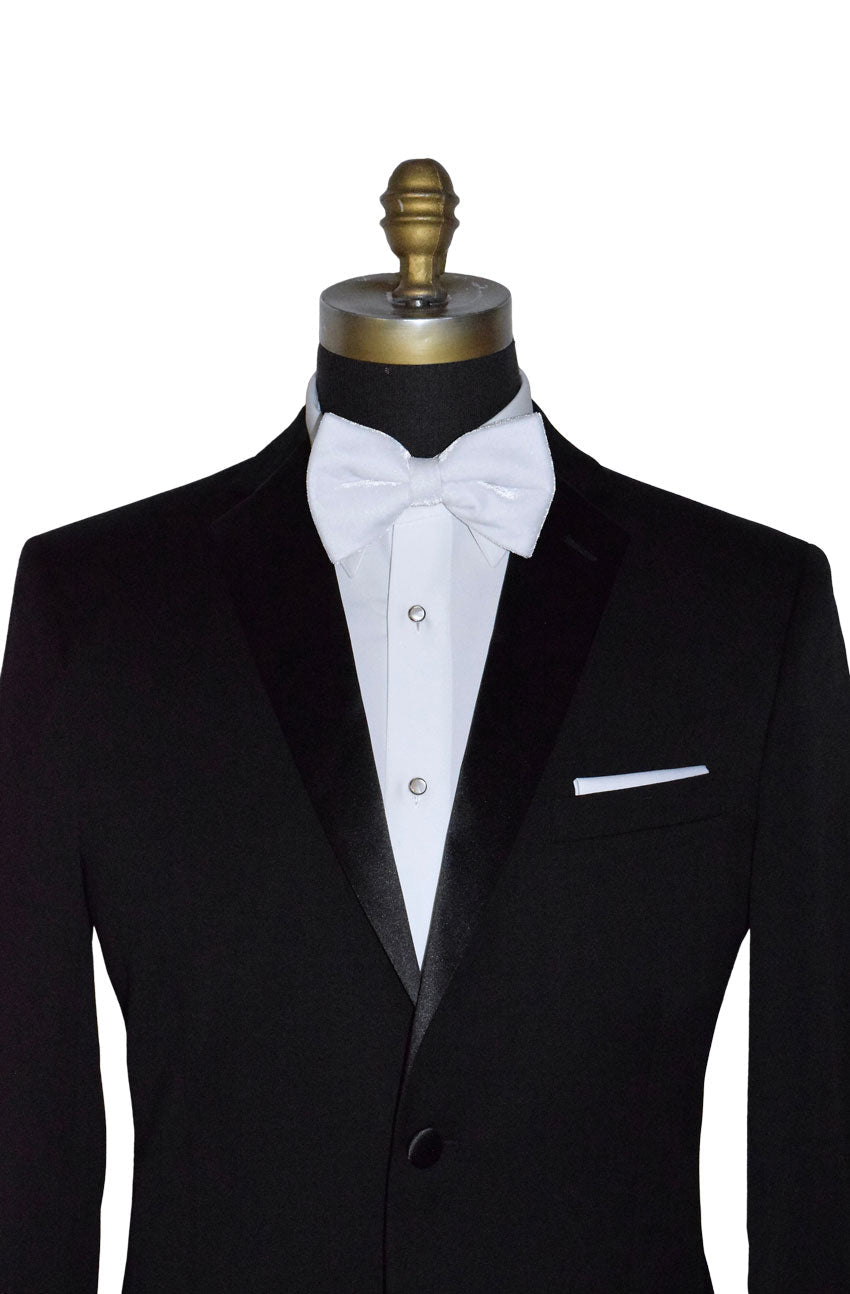 close-up of black tuxedo with white velvet bow tie on a mannequin against a white background