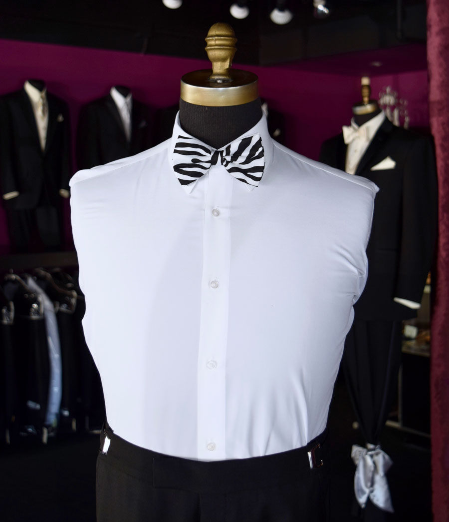 White dress shirt with zebra print bow tie on a mannequin inside a tuxedo shop